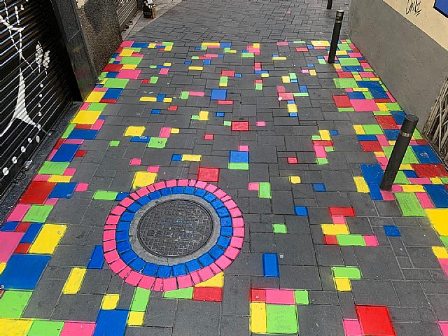 La calle Angustias estrena una alfombra multicolor en sus adoquines